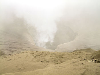 Smoke emitting from volcanic mountain against sky