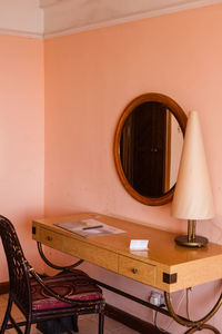 Close-up of electric lamp on table against wall at home