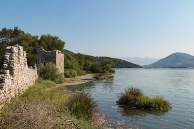 Scenic view of lake and mountains against clear sky