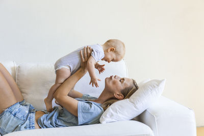 Mother lying on couch holding her baby girl