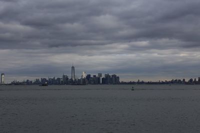 Buildings in city against cloudy sky