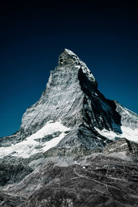 Low angle view of matterhorn mountain against clear blue sky