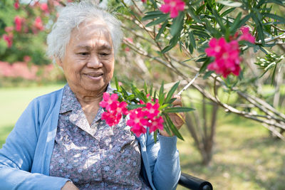 Portrait of woman holding red flower