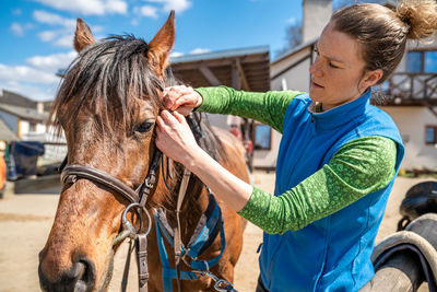 Young woman standing in horse