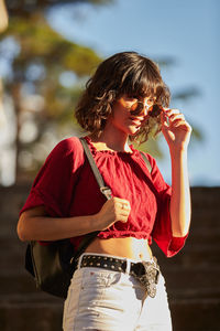 Midsection of woman holding red while standing outdoors