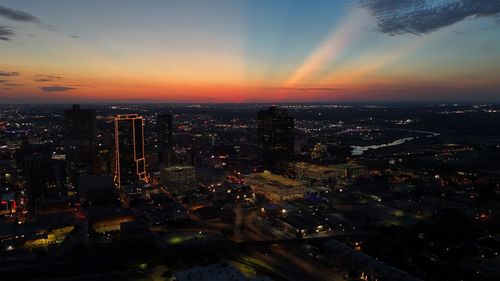 High angle view of illuminated cityscape at sunset