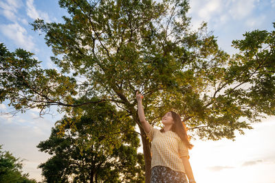 Low angle view of woman standing by plants