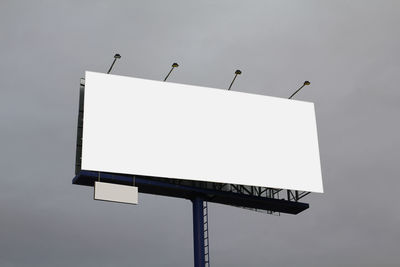 Low angle view of arrow sign against clear sky