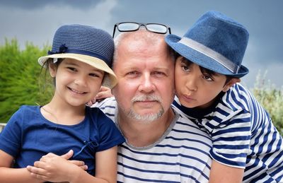 Portrait of grandchild with grandfather against sky