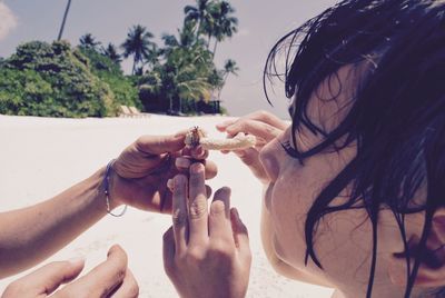 Cropped image of friends with crab at beach