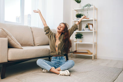 Young woman sitting on sofa at home