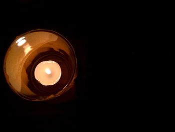 Low angle view of illuminated lamp in darkroom