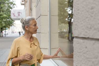 Senior woman looking in shop window