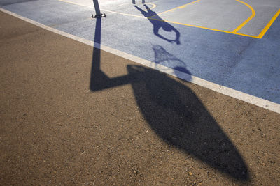 High angle view of shadow of man playing basketball at court