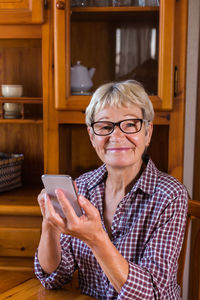 Portrait of woman using smart phone at home