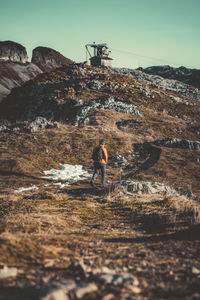 Man skiing on rock against sky