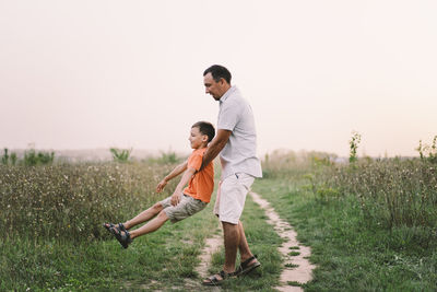 Happy fathers day. father with son are walking in the field.