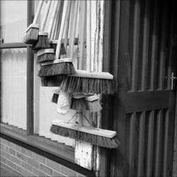 Brooms on building wall for sale at street market