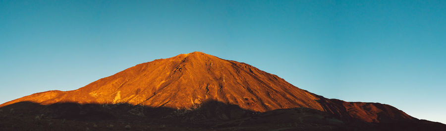 Scenic view of mountain against clear blue sky