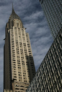 Low angle view of buildings against cloudy sky