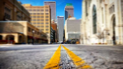 Surface level of road amidst buildings against sky