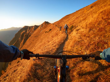 Cropped image of man riding bicycle on mountain