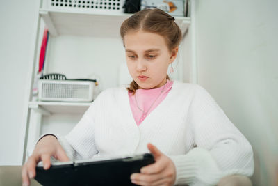 Girl teenager uses tablet learning home