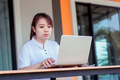 Girl looking away while sitting on table