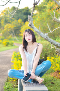 Portrait of young woman sitting on field