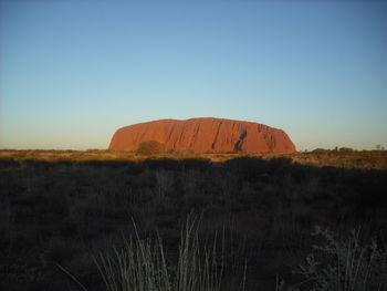 Scenic view of landscape against clear sky at dusk