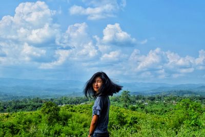 Woman standing by plants against sky
