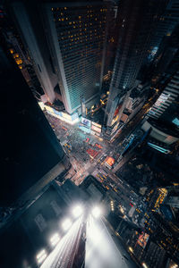 High angle view of illuminated street amidst buildings at night