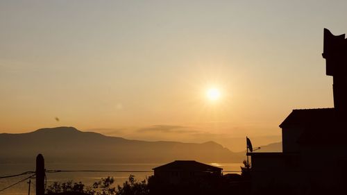 Silhouette buildings against sky during sunset