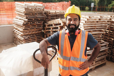 Portrait of smiling worker standing at construction site