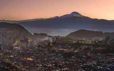 View of city lit up at sunset