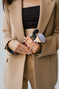 Makeup artist holds makeup brushes in his hands close-up