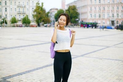 Portrait of smiling woman standing in city