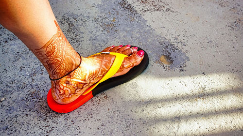 Low section of person wearing red shoes on floor