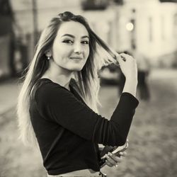 Side view portrait of woman standing on footpath at night