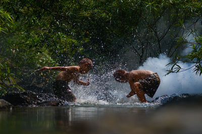 Side view of boys playing in stream