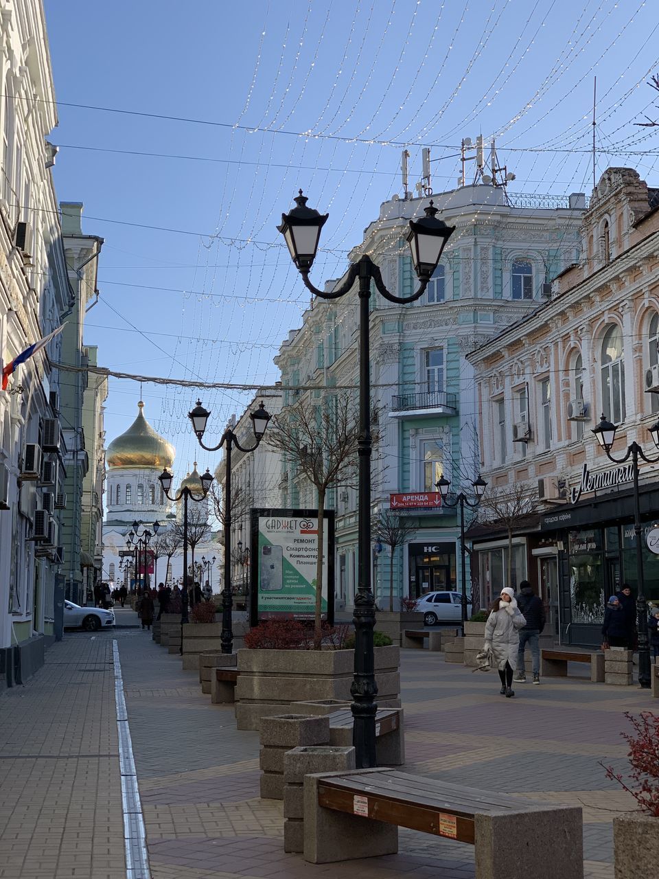 PEOPLE WALKING ON STREET AMIDST BUILDINGS AGAINST SKY