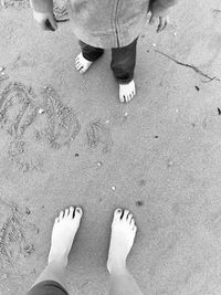 Low section of woman standing on sand