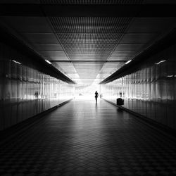 Distance view of woman walking in tunnel