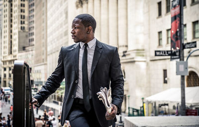 Young man standing in front of office buildings