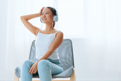 Young woman sitting on sofa at home