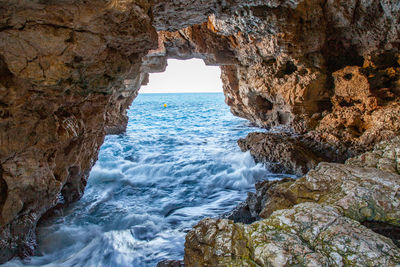 Scenic view of sea seen through rock formation