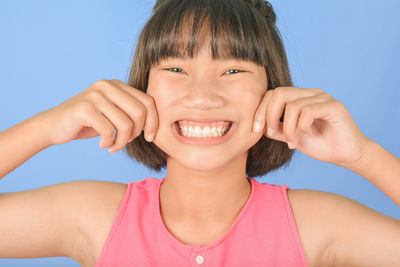 Portrait of a smiling girl against blue background