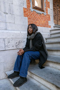 Portrait of young woman sitting on staircase