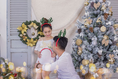 Woman standing by christmas tree