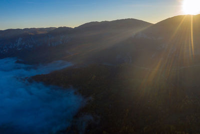 Aerial view of morning fog in the valley in dawn. above the clouds